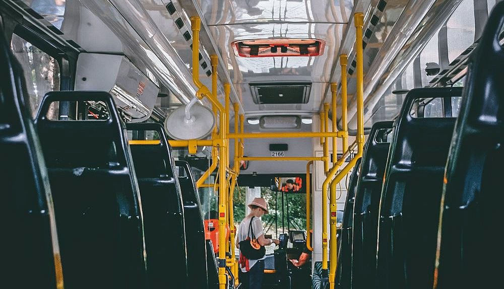 Image of the interior of a bus with a person standing on it.
